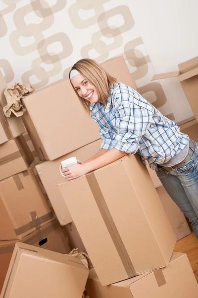 Moving house: Женщина с коробкой в новом доме — стоковое фото