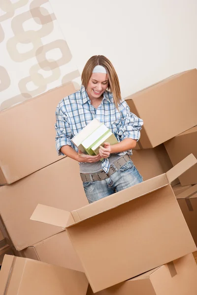 Movendo casa: caixa de desembalagem da mulher com livro — Fotografia de Stock
