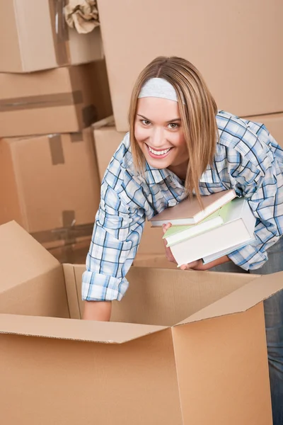 Stěhování: žena rozbalování krabice s knihou — Stock fotografie