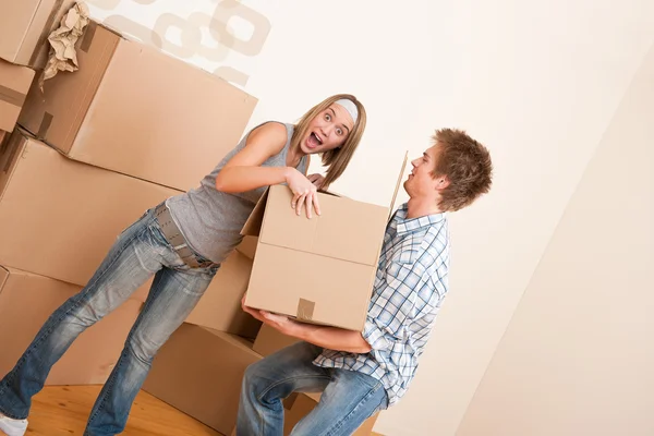 Nueva casa: Caja de mudanza de pareja joven, desembalaje — Foto de Stock