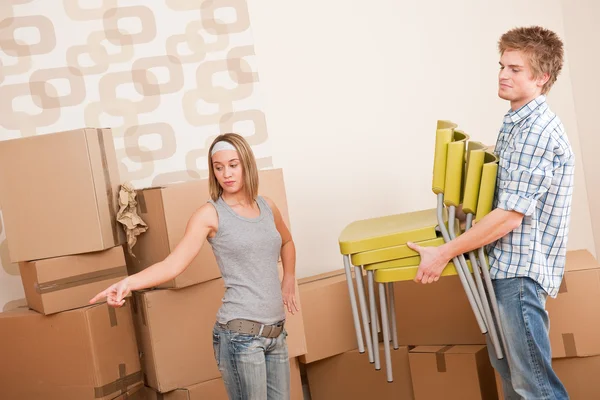 Movendo casa: homem e mulher com caixa e cadeira — Fotografia de Stock
