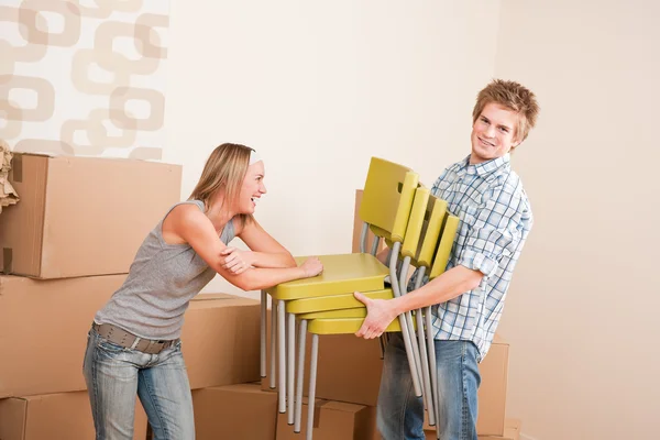 Casa em movimento: Casal jovem com caixa e cadeira — Fotografia de Stock