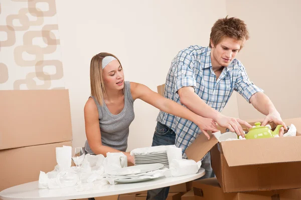 Moving house: Young couple unpacking kitchen dishes — Stock Photo, Image
