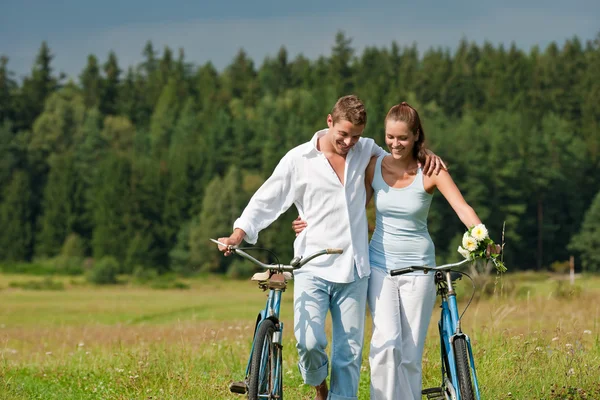 Romantic young couple with old bike in spring nature Stock Image