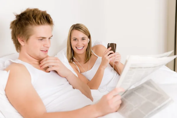 Jovem casal relaxar na cama ouvir música Imagens De Bancos De Imagens Sem Royalties