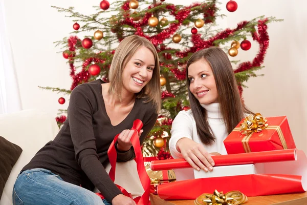 Zwei Frauen packen Weihnachtsgeschenk ein Stockbild