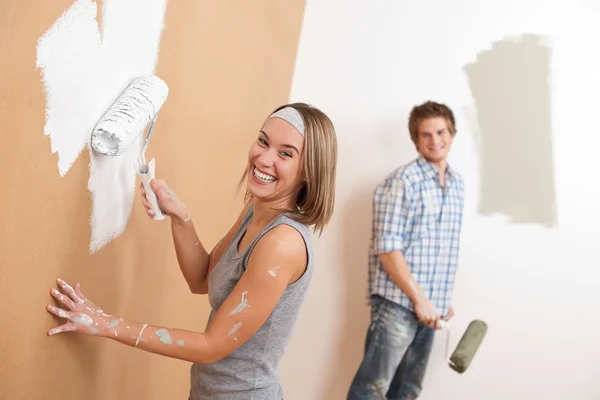 家居装修 年轻夫妇画墙与油漆滚筒 图库图片