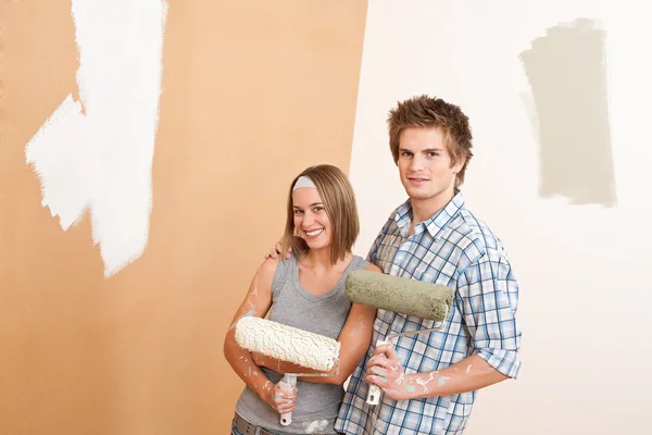 Home improvement: Young man and woman painting wall Stock Picture