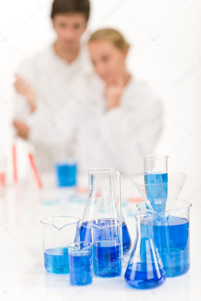 Scientists in laboratory - blue liquid in beakers