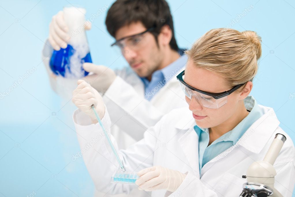 Flu virus experiment - scientist in laboratory with microscope, wear protective eyewear