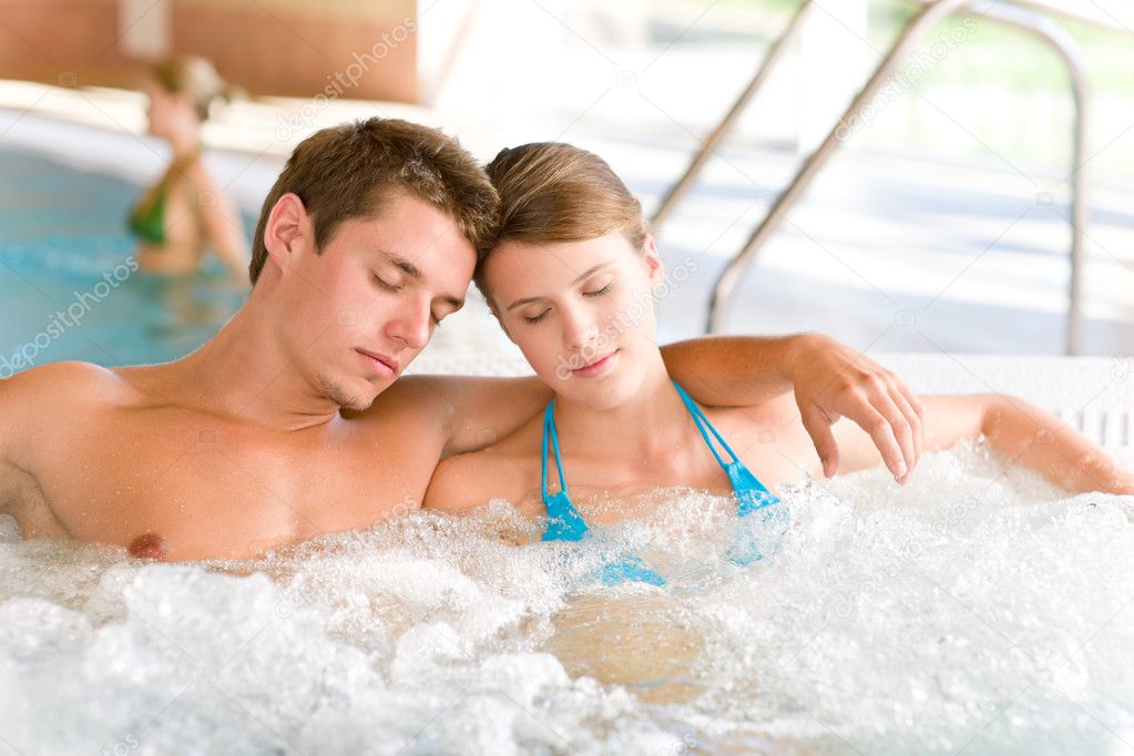 Swimming pool - young attractive couple relax in hot tub