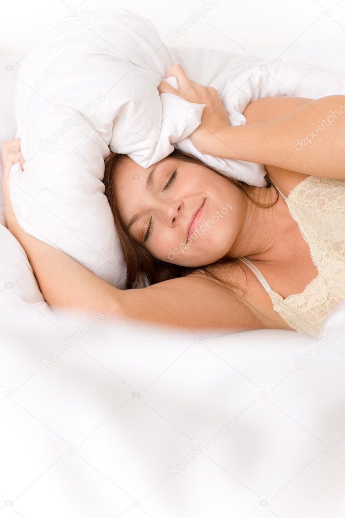 Bedroom - lazy woman getting up blocking ears in white bed