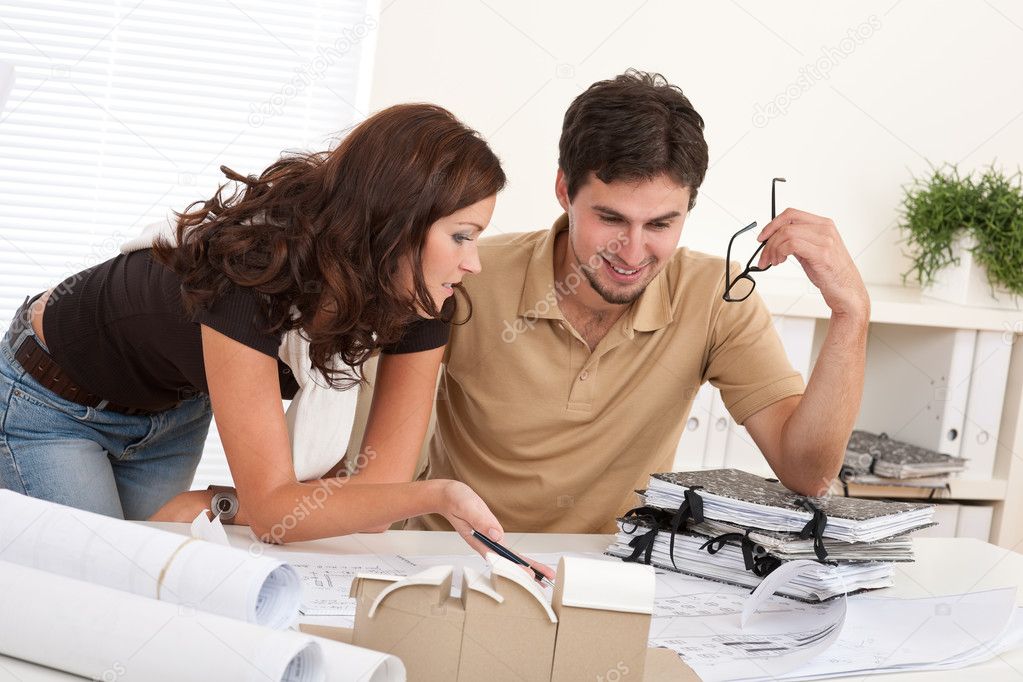 Young man and woman working at architect office together