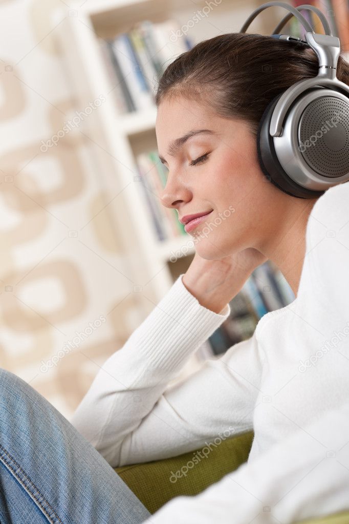 Students - Happy female teenager with headphones listening to music in modern lounge