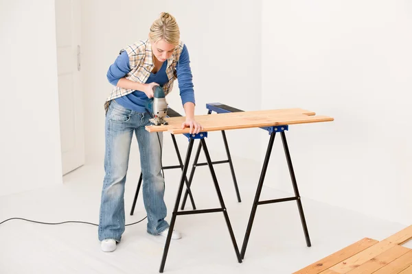 Home improvement - handywoman cutting wooden floor — Stock Photo, Image