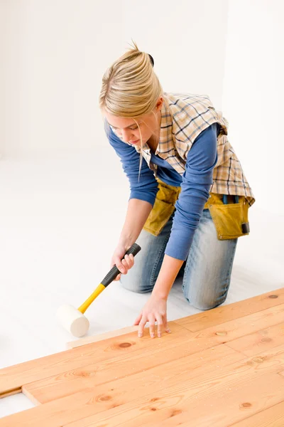 Home improvement - handywoman installing wooden floor — Stock Photo, Image