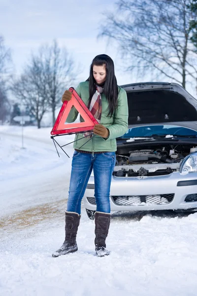 冬の車の故障 女性警告の三角形を配置します — ストック写真