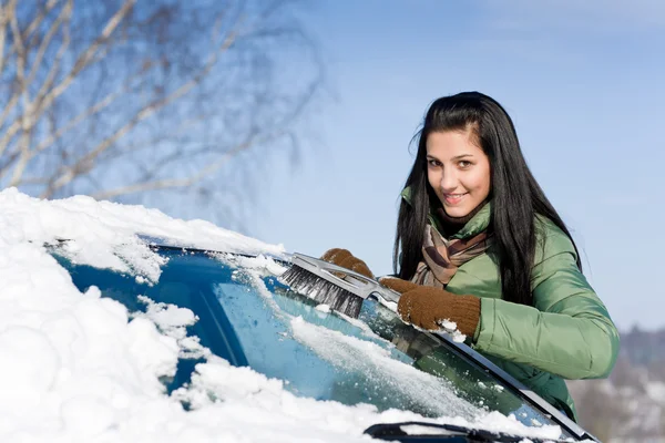 Winterauto - Frau räumt Schnee von Windschutzscheibe Stockbild