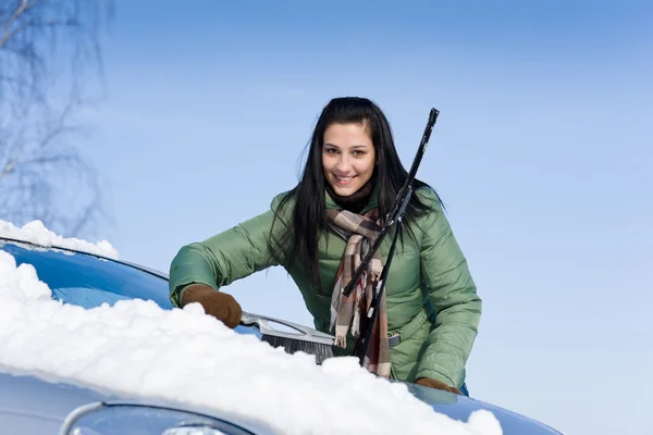冬季车 女人取出雪与雪刷的挡风玻璃 免版税图库图片