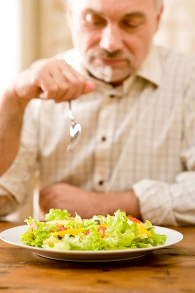 Starszy człowiek dojrzały jeść sałatka jarzynowa — Zdjęcie stockowe