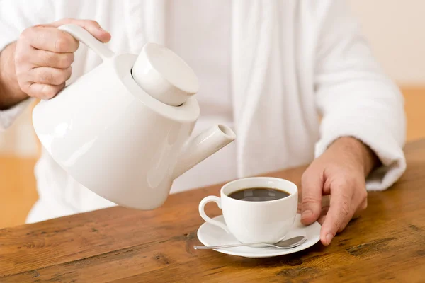 Senior mogen man häller kaffe slitage badrock — Stockfoto