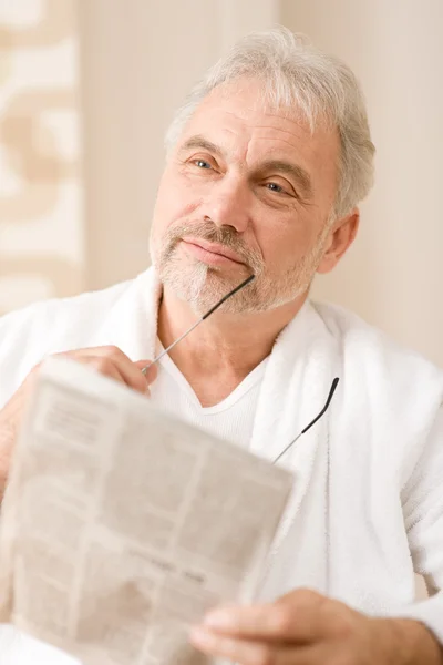 Älterer Mann liest nachdenklich Zeitung — Stockfoto