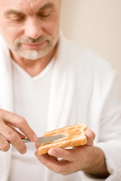 Ανώτερος ώριμος άνδρας, έχοντας πρωινό τοστ — Φωτογραφία Αρχείου