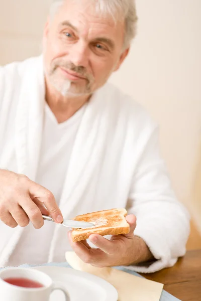 Älterer Mann frühstückt, stößt an — Stockfoto