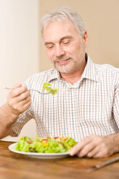 stock image Senior mature man eat vegetable salad