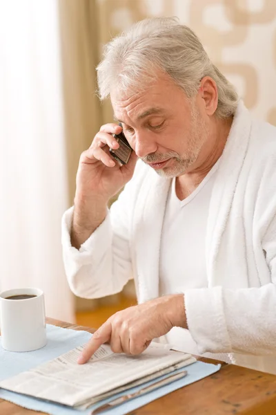 Senior volwassen man - met krant, op telefoon — Stockfoto