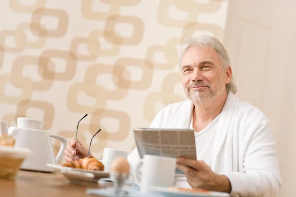 Senior mature man - breakfast at home with newspaper — Stock Photo, Image