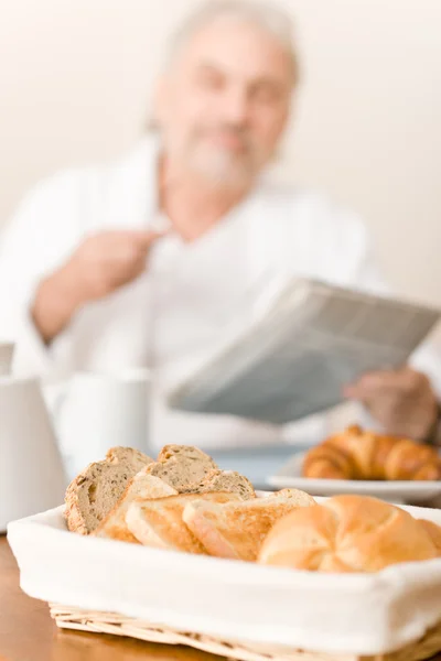 Senior mature man - breakfast pastry and bread — Stock Photo, Image