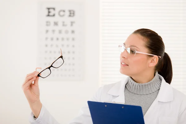 Optiker doktor kvinna med glasögon och öga diagram — Stockfoto