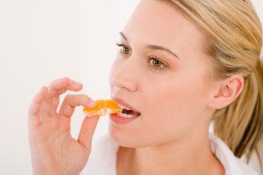 Healthy lifestyle - portrait of woman bite slice of tangerine clipart