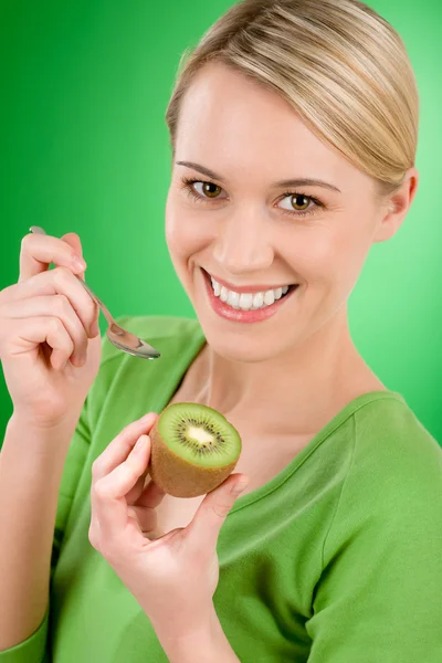 Hälsosam livsstil - glad kvinna med kiwi och tesked — Stockfoto