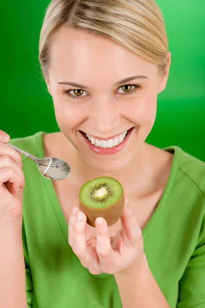 Здоровый образ жизни - счастливая женщина, держащая киви на зеленом — стоковое фото