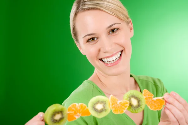 Estilo de vida saludable - mujer comiendo kiwi y naranja —  Fotos de Stock