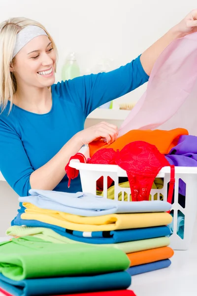 Tvätt - kvinna vika kläder hem — Stockfoto