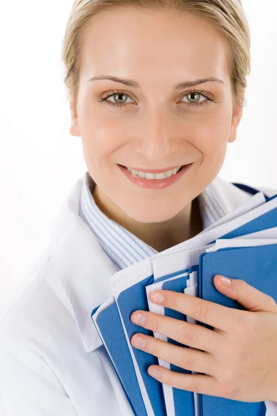Νεαρή γυναίκα γιατρό με ιατρικούς φακέλους σε λευκό — Φωτογραφία Αρχείου