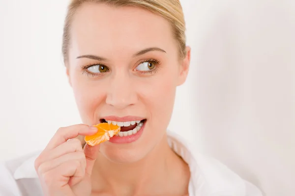 Healthy lifestyle - portrait of woman bite slice of tangerine Stock Photo