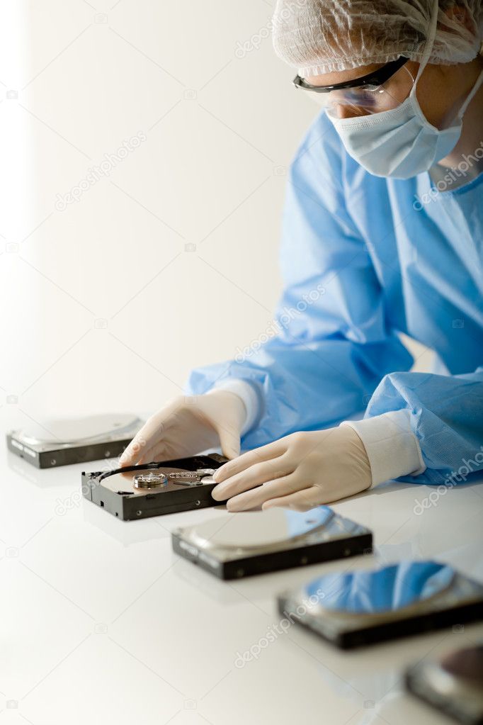 Female computer engineer - woman repair hard disc, sterile