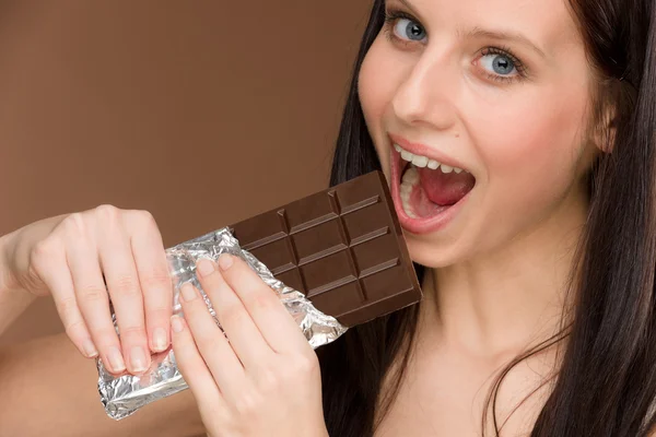 Chocolade - portret jonge vrouw beet snoep — Stockfoto