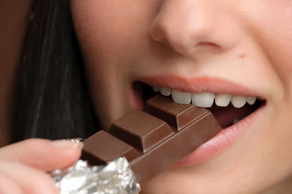 Chocolate - close-up woman bite sweets — Stock Photo, Image