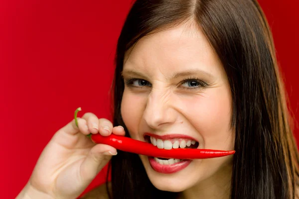 Chilipeppar - stående ung kvinna bita röd kryddig — Stockfoto