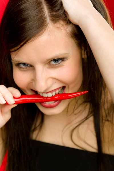 Papryka chili - portret młodej kobiety bite czerwony pikantny — Zdjęcie stockowe