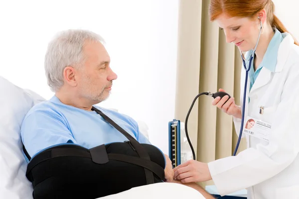 Sjukhus - läkare kontrollera blodtryck patient — Stockfoto