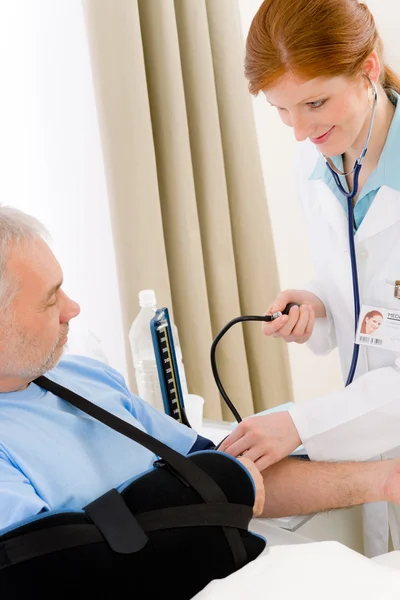 Больница - врач проверяет кровяное давление пациента — стоковое фото
