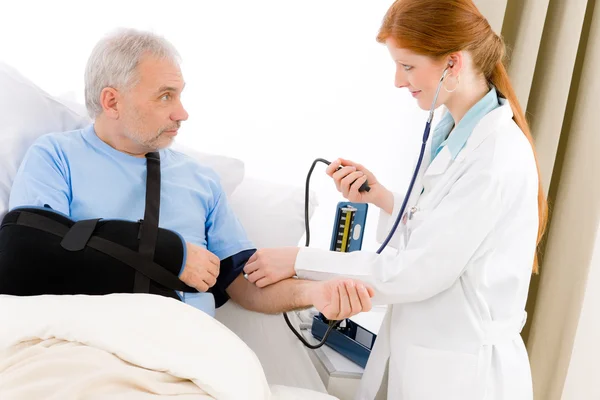 Nemocnice - doktor kontrola krevní tlak pacienta — Stock fotografie