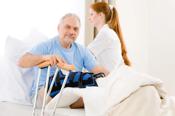 Hospital enfermera cuidado paciente pierna rota — Foto de Stock