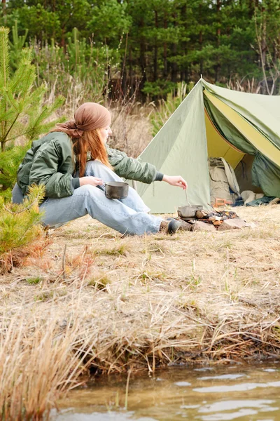 Campeggio donna tenda cucinare cibo fuoco natura — Foto Stock